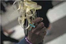  ?? Andrew Caballero-Reynolds / AFP / Getty Images ?? A woman holds a rosary during the Mass attended by hundreds of thousands on Benjamin Franklin Parkway.