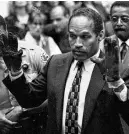  ?? REUTERS ?? O.J. Simpson, wearing the blood-stained gloves found by Los Angeles Police and entered into evidence in Simpson’s murder trial, displays his hands to the jury at the request of prosecutor Christophe­r Darden in this file photograph from June 15, 1995, as his attorney Johnnie Cochran, Jr. looks on.
