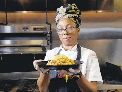  ?? KIM HAIRSTON/BALTIMORE SUN ?? Chef Tonya Thomas, of H3irloom Food Group, holds a plate of sauerkraut.