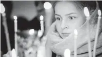  ??  ?? A girl lights candles during an Orthodox Christmas service in a church in Minsk on January 6, 2018. Orthodox Christians celebrate Christmas on January 7 in the Middle East, Russia and other Orthodox churches that use the old Julian calendar instead of...