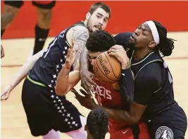  ?? THOMAS SHEA/USA TODAY SPORTS ?? Timberwolv­es forward Josh Okogie, right, tries to grab the ball from Rockets forward Kenyon Martin Jr. on Tuesday.