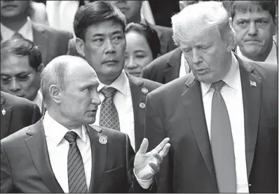  ?? AP/MIKHAIL KLIMENTYEV ?? Presidents Vladimir Putin and Donald Trump talk Saturday during a photo session at the Asian-Pacific Economic Cooperatio­n summit in Danang, Vietnam.