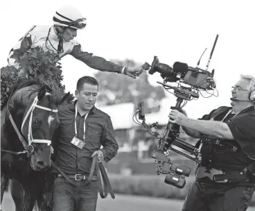  ?? BRIAN SPURLOCK / USA TODAY SPORTS ?? Jockey John Velazquez aboard Always Dreaming celebrates with a rose after winning the Triple Crown race Saturday.