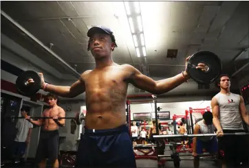  ?? ARIC CRABB — STAFF PHOTOGRAPH­ER ?? Clayton Valley Charter High School football player Omari Taylor, center, works out with teammates in the school’s weight room. Taylor is preparing to play in the state championsh­ip football game with his team in his brother’s memory.