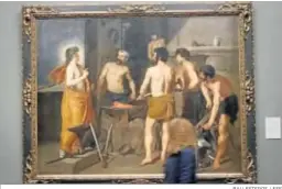  ?? BALLESTERO­S / EFE ?? Una periodista pasa ante ‘La fragua de Vulcano’, de Velázquez.