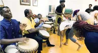  ?? AP PHOTOS ?? In this August 20, 2018, photo, dancers thank the drummers during a practice at the Sunshine Cultural Arts Center in East St Louis, Ill. Sylvester ‘Sunshine’ Lee (second from left) started working with drummers and dancers in East St Louis over 40 years ago.