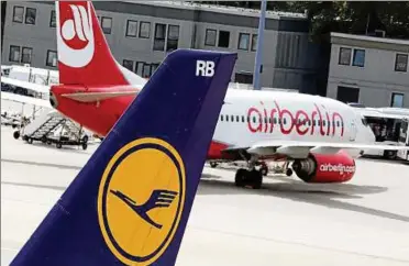  ??  ?? Ein Lufthansa-Flugzeug rollt in Berlin-Tegel an einer Maschine von Air Berlin vorbei. Foto: Wolfgang Kumm