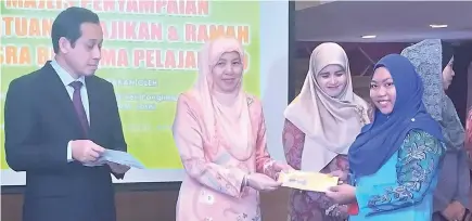  ??  ?? Toh Puan Norlidah (second left) presenting the aid to one of the B40 students together with Kamaruddin (left).