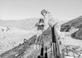  ?? DANIEL OCHOA DE OLZA ASSOCIATED PRESS FILE PHOTO ?? A migrant passes a child to her father after he jumped the border wall to get into the U.S. near San Diego from Tijuana, Mexico, in January. Unpreceden­ted numbers of Central American migrants are crossing into the U.S.