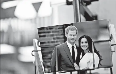  ?? DANIEL LEAL-OLIVAS/AFP-GETTY ?? Royal memorabili­a featuring Prince Harry, Duke of Sussex, and Meghan, Duchess of Sussex, are for sale in a store near Buckingham Palace in London Friday.