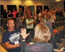  ??  ?? Educators in a session about the connection between the brain and exercise do a high-five activity that involves memorizati­on. The session was part of this year’s “Healthy Bodies, Healthy Minds Institute” at Pottstown Middle School.