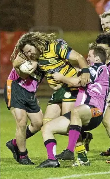  ??  ?? Wattles forward Michael Pearson battles his way through the Southern Sububrbs defence.