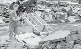  ?? Melissa Phillip / Houston Chronicle ?? A Meyerland resident piles debris in front of his home, which flooded in the aftermath of Hurricane Harvey.