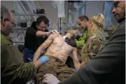  ?? AP PHOTO/EVGENIY MALOLETKA ?? Ukrainian military medics treat their wounded comrade Sunday at the field hospital near Bakhmut, Ukraine.