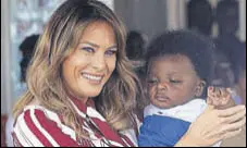  ?? AFP ?? Melania Trump holds a baby in Accra, Ghana, as she embarked on a weeklong tour of Africa, her first solo trip as the US First Lady.