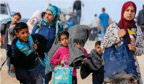  ?? ?? Displaced Palestinia­ns make their way as they attempt to return to their homes in north Gaza. — Reuters