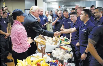  ?? Alex Brandon ?? The Associated Press President Donald Trump, with first lady Melania Trump, greets and hands out sandwiches to members of the U.S. Coast Guard, at the Lake Worth Inlet Station in Riviera Beach, Fla.