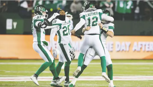  ?? DAVID BLOOM ?? Brett Lauther, second right, is mobbed Saturday after the winning field goal in Edmonton. If the Riders win over the Eskimos at Mosaic Stadium this Saturday, they finish first.