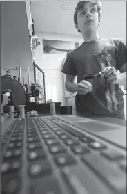  ?? NWA Democrat-Gazette/J.T. WAMPLER ?? Tyler Stacy, an eighth-grader at Washington Junior High School in Bentonvill­e, uses a 3D printer Thursday. Bink designed and printed a a cup holder that will help children with certain developmen­tal disabiliti­es hold a beverage.