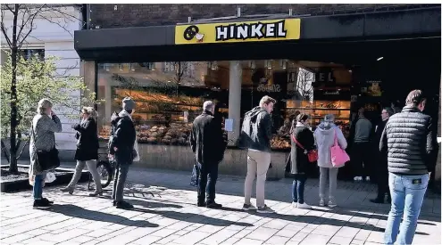  ?? FOTOS: PFW ?? Die Bäckerei Hinkel öffnet in zwei Schichten – die Kunden, die sich sonst drin drängen, warten in einer lockeren Schlange.