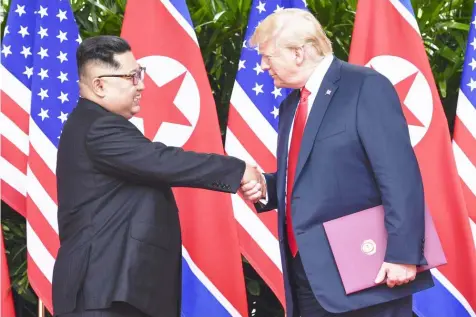  ??  ?? In this June 12, 2018, file photo, North Korea leader Kim Jong Un, left, and U.S. President Donald Trump shake hands at the conclusion of their meetings at the Capella resort on Sentosa Island in Singapore. The series of photos on the front page of the...