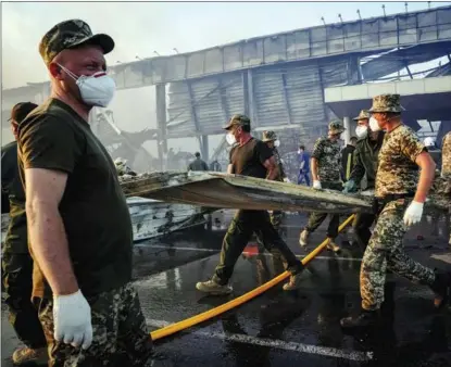  ?? ANNA VOITENKO / REUTERS ?? Rescuers and service members carry out their work in the aftermath of a fire at a shopping mall in the Ukrainian city of Kremenchuk on June 27. Russia said on June 28 that the damage was caused as a result of missile strikes on a nearby weapons depot.