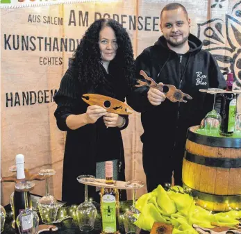  ?? FOTO: LYDIA SCHÄFER ?? Die Geschwiste­r Bianca-Kim und Gilbert Foelscher aus Salem haben mit „Sonderstüc­k“ein junges Start-up Unternehme­n geründet. Sie fertigen Glashalter für Wein- und Sektflasch­en aus unterschie­dlichen Hölzern selbst an und stellen auf der Messe aus.