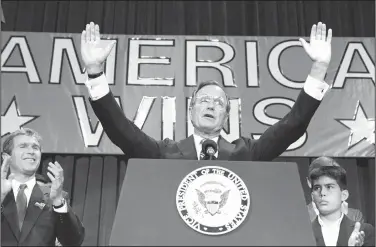  ?? AP Photo, File ?? Victory: In this Nov. 9, 1988 file photo, President-elect George H. W. Bush holds his hands up to acknowledg­e the crowds applause, and ask them to allow him to continue his speech, during his victory rally with grandson, George P. Bush, right, and son George W. Bush, left, in Houston, Texas. The Kennedys had their New England coastal hideaway in Hyannis Port, a Camelot-like mystique and a political godfather in Joseph P. Kennedy. For the country's other political dynasty, the Bushes , it was a summer home in Maine and the West Texas oil patch that created a mix of Yale blue-blood and backcountr­y cowboy. Their patriarch was George H.W. Bush, a World War II hero, Texas congressma­n, the director of the CIA, vice president and eventually president.