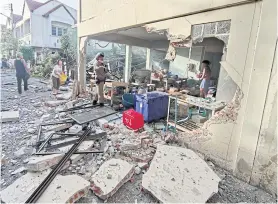  ??  ?? NO SMALL BANG: The walls and windows of a commercial building in Muang district of Ratchaburi are seen blown out following an explosion caused by a gas leak yesterday morning. Four people were injured.