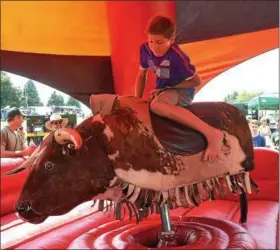  ?? PETE BANNAN – DIGITAL FIRST MEDIA ?? Brent Caprio,13, of Perkiomenv­ille, rides the bull at the Citadel Country Spirit USA Festival at Ludwig’s Corner show grounds Saturday.