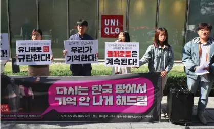  ?? Photograph: Yonhap/AFP via Getty Images ?? Protesters hold a demonstrat­ion denouncing the ad outside a Uniqlo shop in Seoul on Monday.