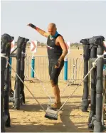  ??  ?? SAND SURFING... A participan­t doing a balancing act to complete an obstacle at the race.