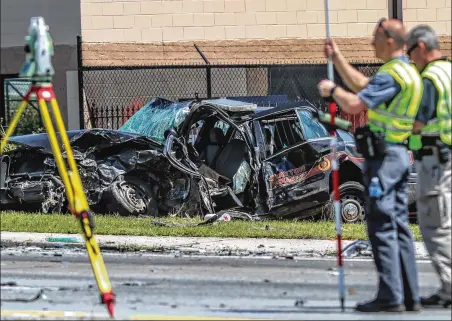  ?? JOHN SPINK/JOHN.SPINK@AJC.COM ?? Investigat­ors work the scene of a car crash that claimed the life of an off-duty Clayton County police officer Monday morning at Tara Boulevard at North Main Street, according to Channel 2 Action News. The officer, who was not immediatel­y identified by authoritie­s, was on his way to a second, part-time job when his car was involved in a collision with a silver sedan, officials said. Both drivers were taken to a hospital, where the officer died and the other driver was listed in serious condition.