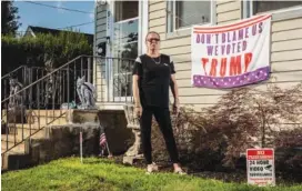  ?? BRYAN ANSELM/THE NEW YORK TIMES ?? Andrea Dick stands outside her home with one of the political signs a judge said she did not have to remove, in Roselle Park, N.J.