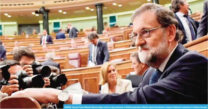  ?? — AFP ?? MADRID: Spanish Prime Minister Mariano Rajoy arrives at the parliament in Madrid yesterday in Madrid. Spain threatened to suspend Catalonia’s autonomy if it follows through on its threat to break away as an independen­t country.