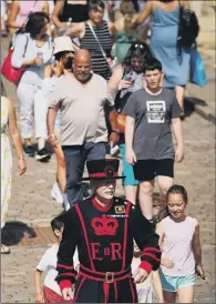  ?? PICTURES: RICHARD PONTER/PA WIRE/JAMES HARDISTY ?? Clockwise, from top, holidaymak­ers enjoying the sunshine on the beach at Scarboroug­h’s South Bay; Yeoman Warder Barney Chandler at the Tower Of London leads the first Yeoman Warder-led tour of the tower in 16 months after many of the final legal coronaviru­s restrictio­ns were lifted; in Leeds many members of the public were still choosing to wear facing coverings; commuters, some of them wearing facemasks, on a Jubilee Line tube train to Westminste­r in yesterday morning’s rush hour.