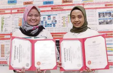  ??  ?? INDRI Yulia (kanan) dan
Amalia Hasanah menunjukka­n sijil tamat latihan dengan Akademi Rel.