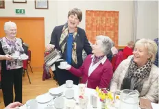  ?? — AFP ?? DUP leader Arlene Foster poses with a teapot as she joins locals for lunch at the Moree Orange Hall near Cookstown on the final day of campaignin­g on Wednesday.