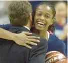  ?? COURANT FILE ?? Cash gets a commemorat­ive basketball and a hug from coach Geno Auriemma for joining the 1,000-point club, one of four seniors to reach the feat in 2002, before a game against Pittsburgh at Gampel Pavilion.