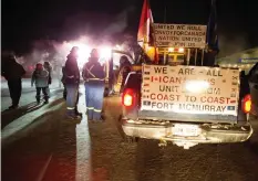  ??  ?? Supporters of a truck convoy headed to Ottawa chat near the Prairie Oasis motel in Moose Jaw. The convoy, which pulled out of Red Deer, Alta. on Thursday morning, expects to make it to Parliament Hill by February 19.