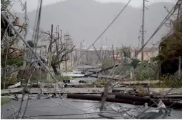  ?? — AFP ?? Electricit­y poles and lines lay toppled after Hurricane Maria hit the eastern region of Puerto Rico on Wednesday.