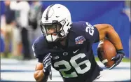  ?? Rick Scuteri / Associated Press ?? Saquon Barkley runs the ball against Washington during the Fiesta Bowl on Dec. 30. He is a top prospect in the upcoming NFL draft.