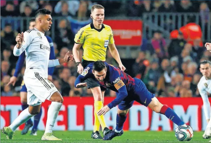  ??  ?? Messi cae en presencia de Casemiro y Valverde, que fueron los dueños del centro del campo del Clásico jugado en el Camp Nou.