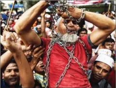  ?? MANAN VATSYAYANA/AFP ?? Ethnic Rohingya Muslim refugees shout slogans as they carry a man in chains during a protest against the persecutio­n of Rohingya Muslims in Myanmar, outside the Myanmar Embassy in Kuala Lumpur, on Friday.