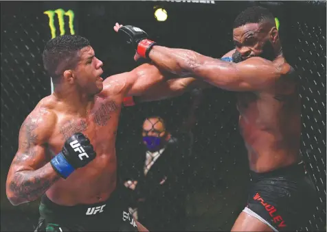  ?? — JEFF BOTTARI/ZUFFA LLC VIA GETTY IMAGES ?? Gilbert Burns of Brazil punches American Tyron Woodley during their welterweig­ht fight at UFC APEX in Las Vegas on Saturday night. Burns won the five-round, UFC Fight Night event.