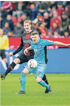  ?? FOTO: DPA ?? Leverkusen­s Julian Brandt (l.) beim Versuch, dem Freiburger Lukas Kübler den Ball abzunehmen.