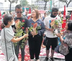  ?? WICHAN CHAROENKIA­TPAKUL ?? FROM LEFT Panupong ‘Mike’ Jadnok, Panusaya ‘Rung’ Sithijiraw­attanakul and Jatupat ‘Pai Dao Din’ Boonpattar­araksa receive flowers from supporters at the Office of the Attorney General yesterday.