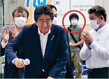  ?? ?? Ready to attack: Tetsuya Yamagami, circled, lurks behind Shinzo Abe at rally