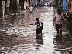  ?? AP ?? A schoolboy wades through waterlogge­d street in Hyderabad yesterday. The city recorded 3cm of rain in just two hours.