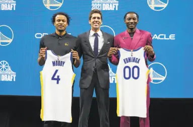  ?? Santiago Mejia / The Chronicle ?? G.M. Bob Myers (center), Moses Moody and Jonathan Kuminga show off the draft picks’ new jerseys.